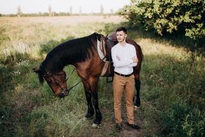 cara de camisa branca em uma caminhada com cavalos marrons foto