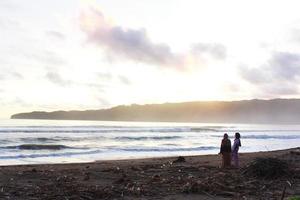 Indonésia 2021. um casal brincando na praia na hora do pôr do sol foto