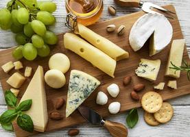 vários tipos de queijo em um fundo branco de madeira