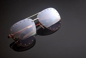 óculos de sol femininos em um fundo escuro com reflexo. lugar para texto foto