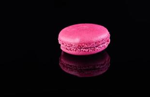 macaron rosa com reflexo em um fundo preto foto
