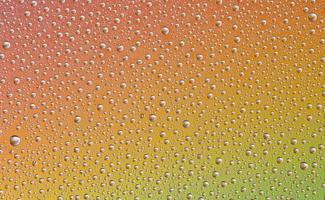 gotas em vidro de diferentes tamanhos e cores sobre um fundo colorido, textura