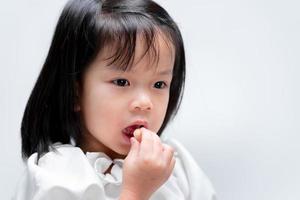 criança come doces doces. sobre fundo branco. foto