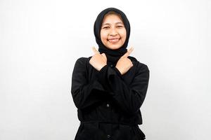 bela jovem asiática muçulmana sorrindo confiante, entusiasmada, alegre com as mãos apontando o espaço vazio, apresentando algo, olhando para a câmera isolada no fundo branco, conceito de publicidade foto