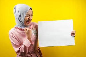 muito jovem mulher muçulmana alegre segurando uma faixa vazia em branco, cartaz, quadro branco, placa de sinalização em branco, quadro de propaganda branco, apresentando algo no espaço da cópia, promoção foto