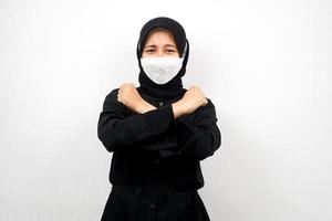 mulher muçulmana usando máscara branca, com o punho cerrado, socando o punho, prevenir o vírus corona, espírito para vencer, isolado no fundo branco foto