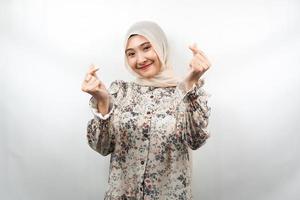 bela jovem asiática muçulmana sorrindo, com sinal de amor coreano, mão perto da câmera, isolado no fundo branco foto