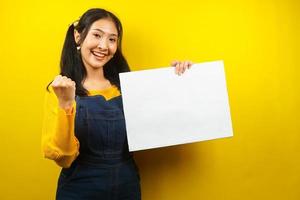 jovem bonita e fofa alegre segurando uma faixa vazia em branco, cartaz, quadro branco, placa de sinalização em branco, quadro de propaganda branco, apresentando algo no espaço da cópia, promoção foto