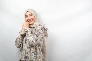 linda jovem muçulmana asiática confiante e alegre, olhando o espaço vazio, apresentando algo, isolado no fundo branco foto