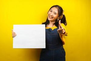 jovem bonita e fofa alegre segurando uma faixa vazia em branco, cartaz, quadro branco, placa de sinalização em branco, quadro de propaganda branco, apresentando algo no espaço da cópia, promoção foto