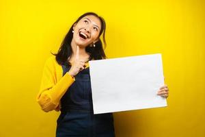 jovem bonita e fofa alegre segurando uma faixa vazia em branco, cartaz, quadro branco, placa de sinalização em branco, quadro de propaganda branco, apresentando algo no espaço da cópia, promoção foto