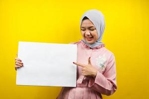 muito jovem mulher muçulmana alegre segurando uma faixa vazia em branco, cartaz, quadro branco, placa de sinalização em branco, quadro de propaganda branco, apresentando algo no espaço da cópia, promoção foto