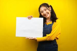 jovem bonita e fofa alegre segurando uma faixa vazia em branco, cartaz, quadro branco, placa de sinalização em branco, quadro de propaganda branco, apresentando algo no espaço da cópia, promoção foto