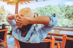 homem asiático viajar natureza. viajar relaxar. sente-se em uma cafeteria. foto