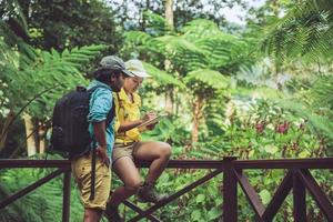 casal asiático viaja a natureza caminhando, relaxa e estuda a natureza na floresta. foto