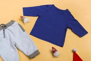 raglan infantil azul, camisa pólo com calça de moletom em fundo colorido, vista de cima da blusa, simulação com espaço de cópia