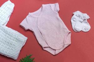 maquete de bodysuit de bebê rosa de Natal em fundo colorido fechar com maquete de roupas de recém-nascido de jaqueta branca de malha. com espaço de cópia