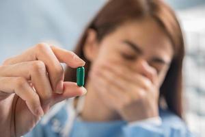 mão de uma mulher segurando um comprimido tomar remédio de acordo com a ordem do médico foto