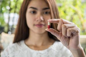 mão de uma mulher segurando um comprimido tomar remédio de acordo com a ordem do médico foto
