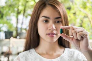 mão de uma mulher segurando um comprimido tomar remédio de acordo com a ordem do médico foto