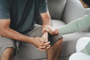 amiga ou família sentada e de mãos dadas durante animar o homem deprimido mental, o psicólogo fornece ajuda mental ao paciente. conceito de saúde mental ptsd foto