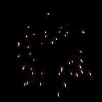 fogos de artifício laranja estourados no ar iluminam o céu com uma exibição deslumbrante e festivais de fogos de artifício coloridos no preto. foto