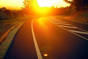 laranja do sol na trilha da estrada bela estrada transformando nas colinas e estrada de montanha estrada de pastagem à noite em. foto