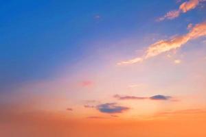 pôr do sol e nuvem laranja e céu azul do amanhecer com efeito de movimento de linhas horizontais de nuvem no fundo do sol. foto
