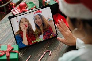 videochamada de natal e ano novo com um amigo e um tablet juntos em casa foto