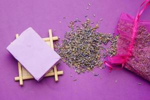 sabonete natural caseiro e flor de lavanda em fundo roxo foto