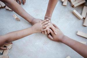 mãos de crianças diversas estão juntas no fundo de concreto foto