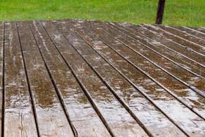 chuva caindo no terraço de madeira foto