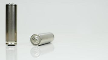 AA baterias recarregáveis alcalinas em fundo branco brilhante com reflexo. feche duas baterias vazias com espaço de cópia. foto