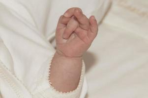 a mão de um bebê na igreja na cerimônia de batismo. religião. fechar-se.