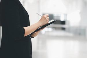 mulher asiática trabalhando mulher segurando um tablet no escritório trabalhando conceito mulher mulher de negócios com tecnologia foto