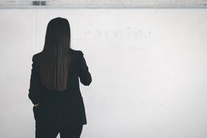 uma jovem professora asiática em frente a uma sala de aula na universidade. foto