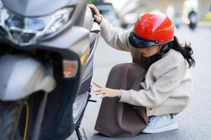 menina asiática quebrou a moto a caminho do trabalho foto