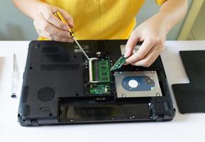 reparadores estão consertando e limpando laptops periodicamente foto