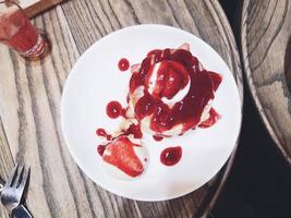 panqueca fofa caseira e calda doce - deliciosas panquecas com molho de morango e sorvete na mesa de jantar no café restaurante foto