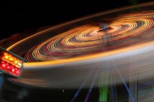 roda gigante gira rápido na noite escura foto