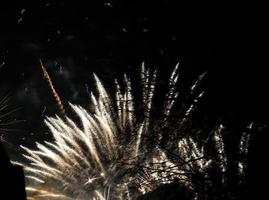 estouro de fogos de artifício coloridos no céu escuro da noite foto