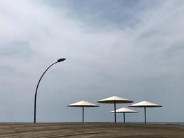 espreguiçadeira elegante na areia amarela para tomar sol na praia foto