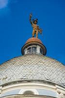estátua de mercúrio no topo do telhado de um prédio em novi sad, sérvia foto