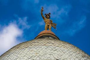 estátua de mercúrio no topo do telhado de um prédio em novi sad, sérvia foto