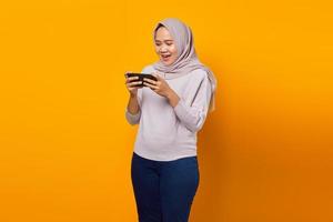 retrato de uma jovem asiática feliz jogando videogame no celular foto