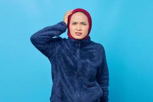 retrato de uma linda mulher asiática se sentindo frustrada e irritada com um fundo azul foto