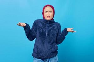 retrato de uma jovem asiática zangada com uma discussão com as mãos levantadas sobre um fundo azul