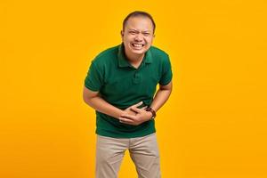 jovem asiático atraente rindo alto de uma coisa engraçada sobre fundo amarelo foto