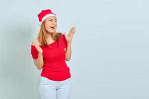 bela jovem asiática com vestido de natal, mostrando rosto alegre e animado sobre fundo branco foto