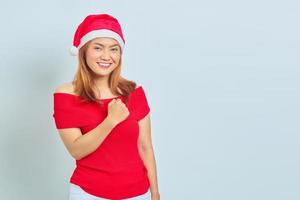 jovem asiática alegre com vestido de natal animada para celebrar o natal sobre fundo branco foto